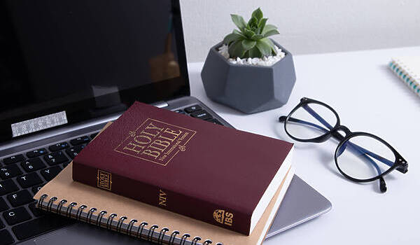 Bible And Laptop On The Work Table With Glasses. Holy Bible Study Online